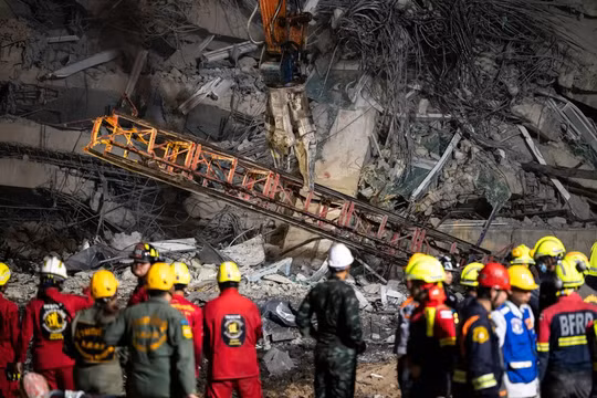 Đống đổ nát của một cần cẩu đang được máy móc hạng nặng di dời tại tại địa điểm một tòa nhà đang xây dựng bị sập ở Bangkok, Thái Lan hôm 30/3. Ảnh: Getty.