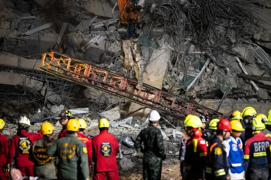 Đống đổ nát của một cần cẩu đang được máy móc hạng nặng di dời tại tại địa điểm một tòa nhà đang xây dựng bị sập ở Bangkok, Thái Lan hôm 30/3. Ảnh: Getty.