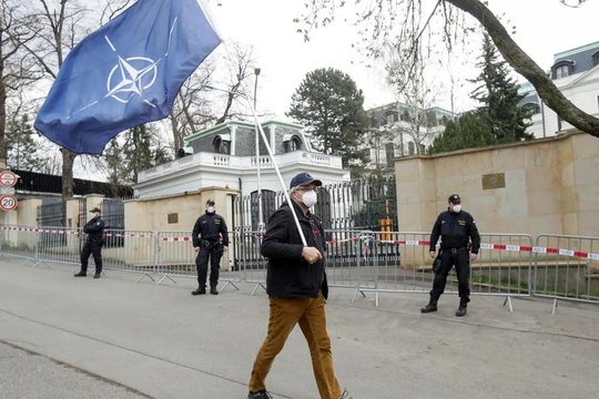 Một người đàn ông mang cờ NATO trước cửa Đại sứ quán Nga ở Praha, CH Séc (Ảnh: RT)