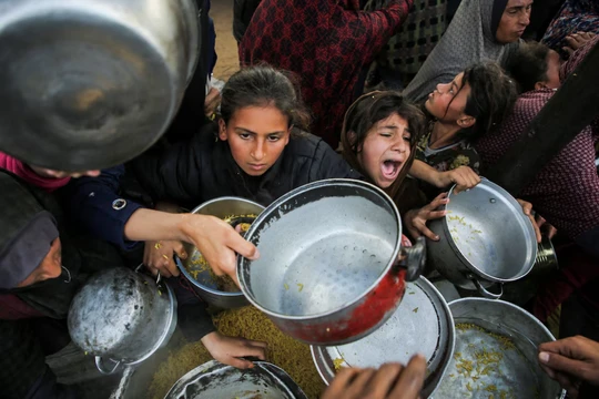 Người Palestine tụ tập để nhận thức ăn do một bếp từ thiện nấu ở Khan Younis, phía nam Dải Gaza, ngày 17/1. Ảnh: Reuters.