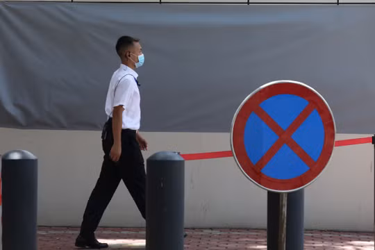 Một nhân viên an ninh băng qua tấm biển cấm vào bên ngoài tòa lãnh sự quán Mỹ ở Thành Đô (Ảnh: SCMP)