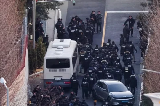 Các sĩ quan cảnh sát và điều tra viên của CIA đi qua lối vào dinh thự chính thức của Tổng thống Hàn Quốc bị luận tội Yoon Suk Yeol, ngày 15/1. Ảnh: Reuters.