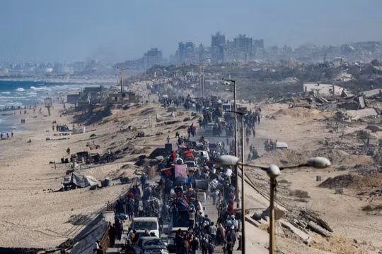 Người dân Palestine, những người phải di dời đến phía nam Gaza theo lệnh của Israel, di chuyển dọc theo một con đường khi họ trở về phía bắc, trong bối cảnh lệnh ngừng bắn giữa Israel và Hamas ở Gaza, ngày 11/10. Ảnh: Reuters.