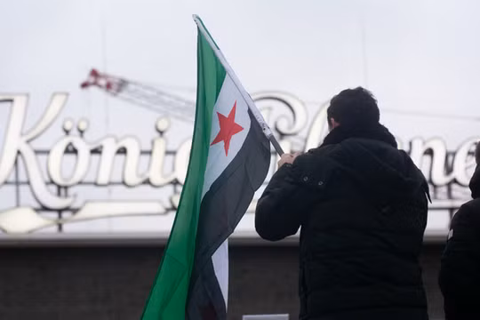 Người Syria tị nạn phản ứng trước những diễn biến mới ở Syria tại Ga trung tâm Duisburg ở Duisburg, Đức. Ảnh: Getty.