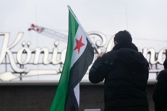 Người Syria tị nạn phản ứng trước những diễn biến mới ở Syria tại Ga trung tâm Duisburg ở Duisburg, Đức. Ảnh: Getty.