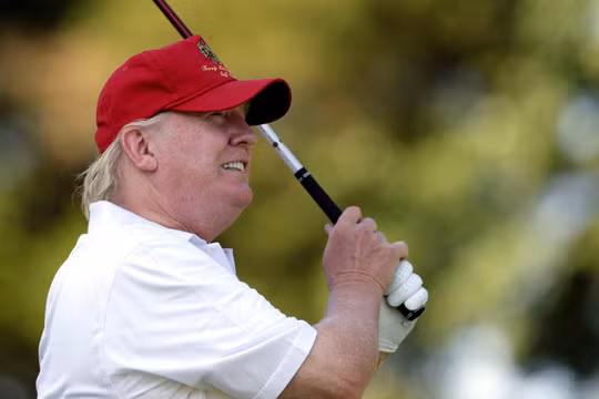 Tổng thống Trump trong một buổi đánh golf (Ảnh : Boston Globe)