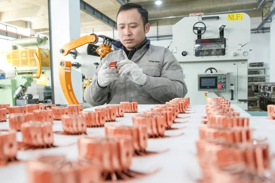 Một công nhân sản xuất các bộ phận pin cho xe sử dụng năng lượng mới để xuất khẩu tại một xưởng ở Hồ Châu, Trung Quốc. Ảnh: Getty.