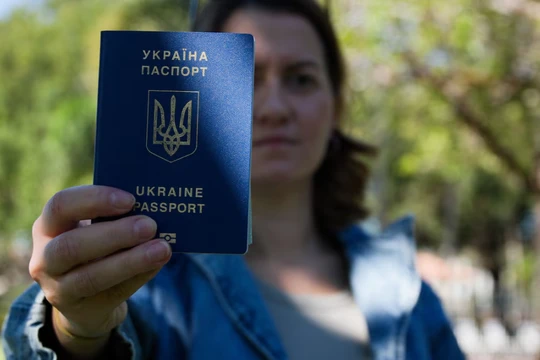 Bà Kateryna Golizdra cầm hộ chiếu Ukraine của mình để chụp ảnh bên ngoài nhà mình ở Margate, Florida, Mỹ ngày 17/11. Ảnh: Reuters.