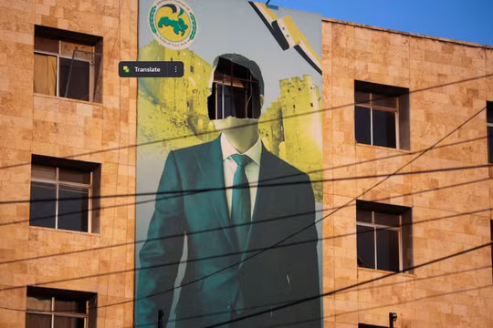 Tấm áp phích có hình Tổng thống Syria Bashar al-Assad bị hư hại ở Aleppo, sau khi quân đội Syria cho biết hàng chục binh sĩ của họ đã thiệt mạng trong một cuộc tấn công lớn của phiến quân tràn vào thành phố ngày 30/11. Ảnh: Reuters.