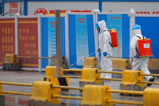 Nhân viên y tế tiến hành khử trùng trước một khu chợ ở Vũ Hán, tỉnh Hồ Bắc, Trung Quốc (Ảnh: Reuters)