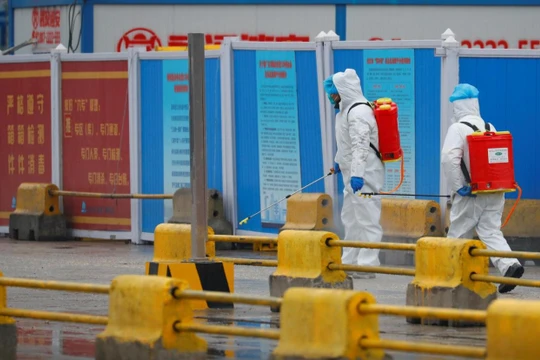 Nhân viên y tế tiến hành khử trùng trước một khu chợ ở Vũ Hán, tỉnh Hồ Bắc, Trung Quốc (Ảnh: Reuters)