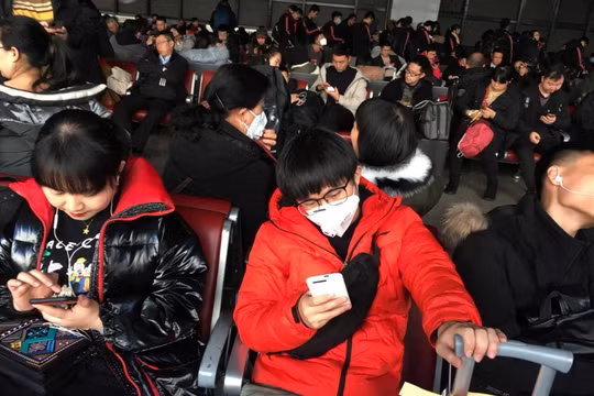 Nhiều hành khách mang khẩu trang khi chờ tàu tại Trạm đường sắt phía Tây để bắt tàu tới Vũ Hán (Ảnh: Reuters)