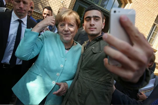 Thủ tướng Đức Angela Merkel chụp ảnh với Anas Modamani, một người tị nạn từ Syria, sau khi bà đến thăm nơi trú ẩn cho người di cư và người tị nạn ở Berlin, Đức vào ngày 10/9/2015. Ảnh: Getty.