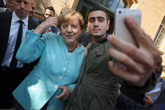 Thủ tướng Đức Angela Merkel chụp ảnh với Anas Modamani, một người tị nạn từ Syria, sau khi bà đến thăm nơi trú ẩn cho người di cư và người tị nạn ở Berlin, Đức vào ngày 10/9/2015. Ảnh: Getty.