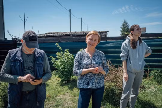Vadym Smirnov, Alla Voloshynovych cô con gái Anastasia Smirnov đứng trên mảnh vườn đã được dọn gần hết mảnh đạn (Ảnh: Al Jazeera)