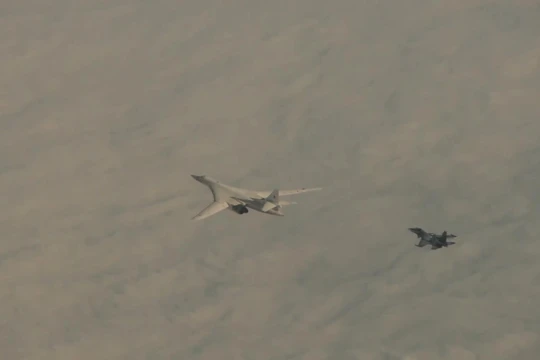 Máy bay ném bom Tu-160 của Nga được hộ tống bởi một chiếc Su-30SM (Ảnh: RT)