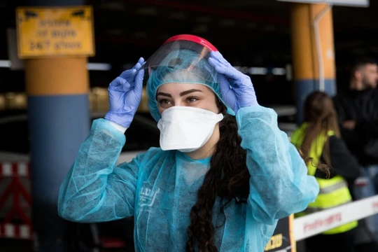 Nhân viên Trung tâm Y tế Shaare Zedek Medical (Jerusalem) mang đồ phòng hộ chuẩn bị khám cho một phụ nữ Trung Quốc nghi nhiễm virus corona (Ảnh: Israel21c)