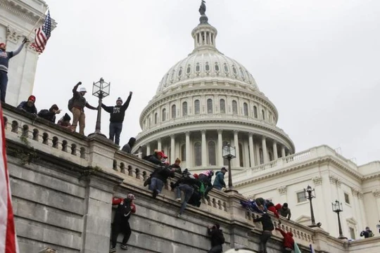 Người biểu tình trèo lên tường tòa nhà Quốc hội Mỹ hòng thâm nhập vào bên trong (Ảnh: Reuters)