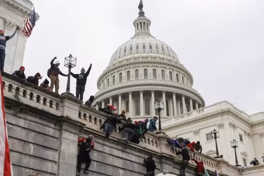 Người biểu tình trèo lên tường tòa nhà Quốc hội Mỹ hòng thâm nhập vào bên trong (Ảnh: Reuters)