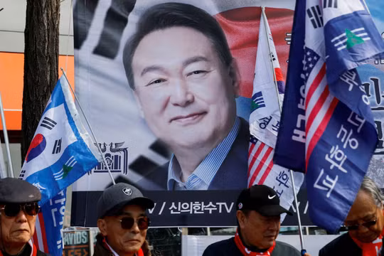 Những người biểu tình đứng trước biểu ngữ có ảnh ông Yoon Suk-yeol khi mọi người chờ đợi phán quyết của Tòa án Hiến pháp về việc luận tội Tổng thống, ngày 4/4. Ảnh: Reuters.