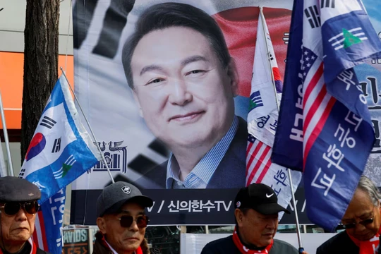 Những người biểu tình đứng trước biểu ngữ có ảnh ông Yoon Suk-yeol khi mọi người chờ đợi phán quyết của Tòa án Hiến pháp về việc luận tội Tổng thống, ngày 4/4. Ảnh: Reuters.