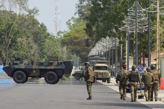 Binh lính tuần tra trước trụ sở đài phát thanh và truyền hình Benin, sau khi lực lượng vũ trang của nước này đã ngăn chặn âm mưu đảo chính chống lại chính phủ của Tổng thống Benin Patrice Talon, tại Cotonou, Benin, ngày 7/12. Ảnh: Reuters.