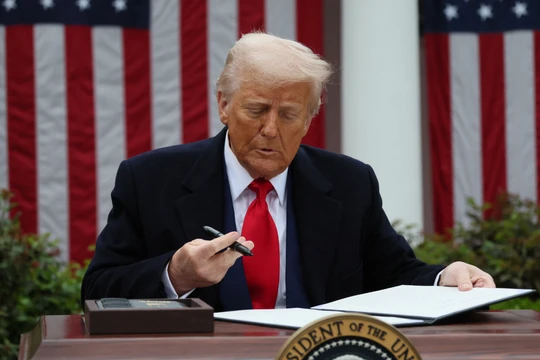 Tổng thống Mỹ Donald Trump ký lệnh hành pháp về thuế quan tại Vườn Hồng thuộc Nhà Trắng ngày 2/4. Ảnh: Reuters.