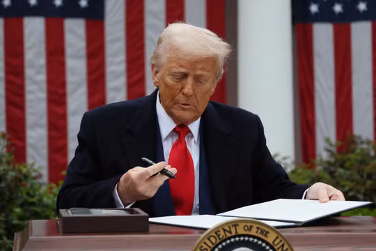 Tổng thống Mỹ Donald Trump ký lệnh hành pháp về thuế quan tại Vườn Hồng thuộc Nhà Trắng ngày 2/4. Ảnh: Reuters.