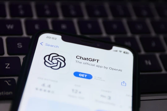 Bàn phím máy tính xách tay và trang web ChatGPT hiển thị trên màn hình điện thoại. Ảnh: Getty.