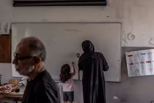 Youseff Nasser cùng vợ và cháu gái tại một nơi trú ẩn ở trường học ở Aley, Lebanon sau khi chạy trốn khỏi làng Aita al-Shaab của họ (Ảnh: WSJ)