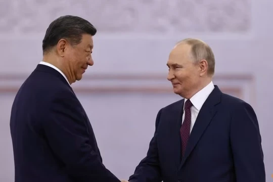 Tổng thống Nga Vladimir Putin bắt tay Chủ tịch Trung Quốc Tập Cận Bình trong buổi lễ chào mừng trước cuộc hội đàm tại Điện Kremlin ở Moscow, Nga, vào ngày 8/5. Ảnh: Reuters.