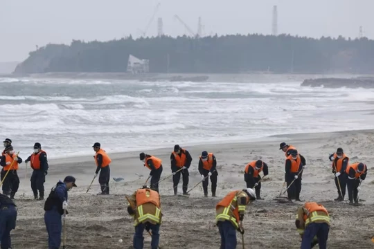 Cảnh sát tìm kiếm manh mối về những người mất tích trong thảm họa động đất và sóng thần năm 2011 gần nhà máy điện hạt nhân Fukushima Daiichi vào ngày kỷ niệm 14 năm thảm họa, tại thị trấn Namie, tỉnh Fukushima, Nhật Bản hôm 11/3. Ảnh: Reuters.
