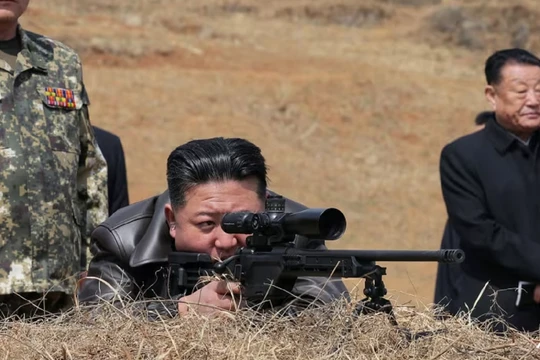Nhà lãnh đạo Triều Tiên Kim Jong-un đang nhìn qua ống ngắm súng bắn tỉa khi ông đến thăm căn cứ huấn luyện của lực lượng tác chiến đặc biệt của Quân đội Nhân dân Triều Tiên. Ảnh: AFP.