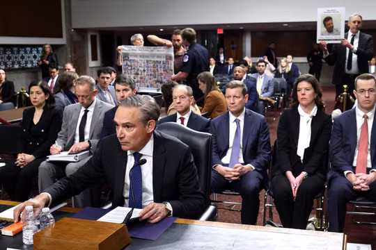 Tổng giám đốc điều hành Boeing Kelly Ortberg làm chứng trước một ủy ban Thượng viện khi những người biểu tình giơ cao các tấm biển mô tả các nạn nhân của vụ tai nạn 737 MAX. Ảnh: Getty.