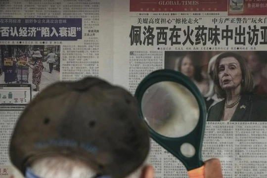 Một người dân đọc tin về bà Pelosi trên tờ Thời báo Hoàn cầu tại một sạp báo ở Bắc Kinh (Ảnh: AP)