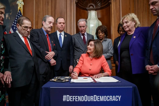 Chủ tịch Hạ viện Nancy Pelosi ký 2 điều khoản luận tội Trump để chuyển cho Thượng viện (Ảnh: Guardian)