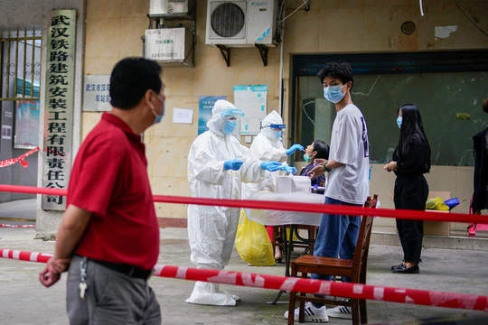 Nhân viên y tế mang đồ bảo hộ xét nghiệm COVID-19 cho người dân tại một khu dân cư ở Vũ Hán, tỉnh Hồ Bắc, Trung Quốc (Ảnh: Reuters)