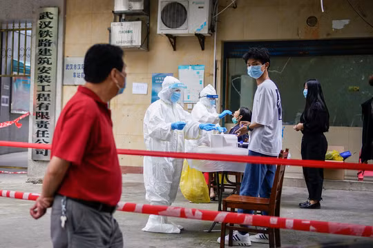 Nhân viên y tế mang đồ bảo hộ xét nghiệm COVID-19 cho người dân tại một khu dân cư ở Vũ Hán, tỉnh Hồ Bắc, Trung Quốc (Ảnh: Reuters)