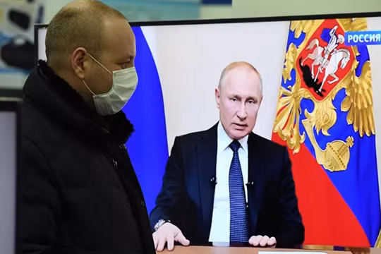 Một người dân theo dõi ông Putin phát biểu trên truyền hình (Ảnh: Sputnik)