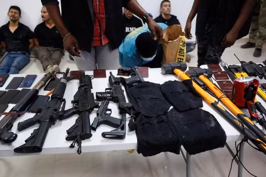 Các nghi phạm vụ ám sát Tổng thống Haiti cùng lượng lớn vũ khí, tang vật bị thu giữ (Ảnh: Reuters)