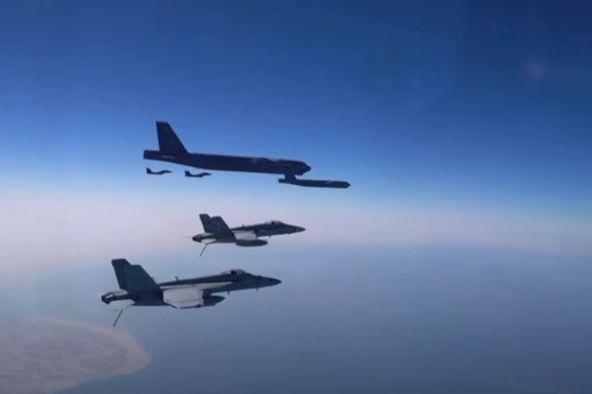 Máy bay ném bom B-52 Stratofortress của Mỹ được hộ tống bởi các chiến đấu cơ (Ảnh: RT)