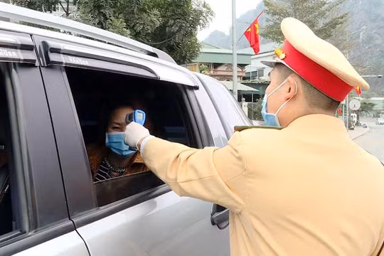 Công an TP Cẩm Phả vừa điều tiết giao thông vừa kết hợp với đo nhiệt độ người tham gia giao thông. Ảnh: UBND tỉnh Quảng Ninh.