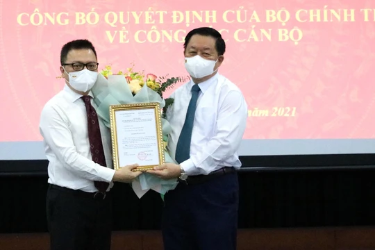 Ông Lê Quốc Minh nhận quyết định và hoa chúc mừng từ ông Nguyễn Trọng Nghĩa.