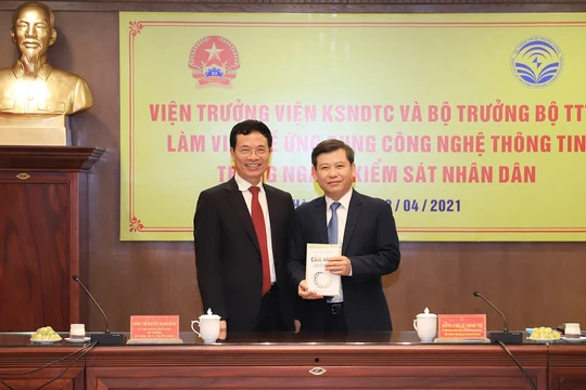 Bộ trưởng Nguyễn Mạnh Hùng tặng cuốn "Cẩm nang chuyển đổi số" cho Viện trưởng VKSNDTS Lê Minh Trí. Ảnh: VKSNDTC