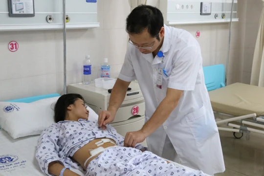 Bác sĩ thăm khám cho T. sau phẫu thuật