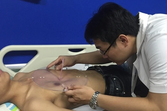 Bác sĩ kiểm tra vùng lõm ngực của bệnh nhi sau khi điều trị bằng phương pháp mới