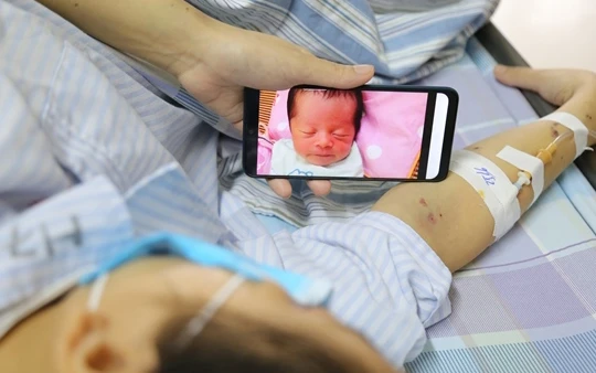 Chị Vang ngắn nhìn đứa con thơ trong lúc điều trị ung thư máu.