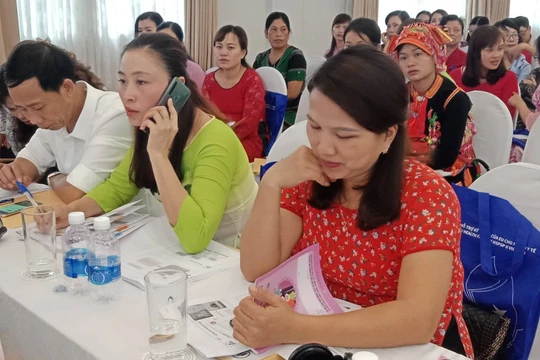 Các đại biểu tại Hội nghị xem sổ theo dõi sức khỏe bà mẹ và trẻ em