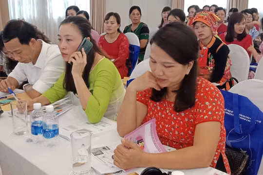 Các đại biểu tại Hội nghị xem sổ theo dõi sức khỏe bà mẹ và trẻ em