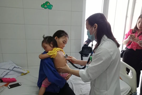 Bác sĩ khám cho trẻ nhỏ mắc sởi